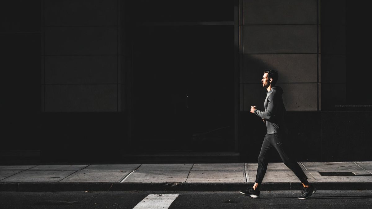 A confident adult mid-stride on a morning street